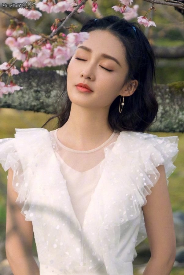 The beauty Li Qin under the peach blossom tree wears a white dress and looks fresh and refined(2/4)