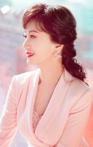 赵雅芝西装粉裙秀玉腿 嘴涂紫红唇膏笑容妩媚