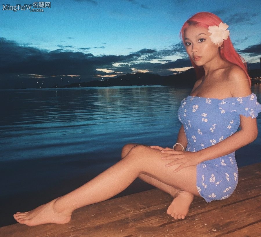 万妮达穿低胸短裙坐在海边展示长腿和玉足（第1张/共2张）