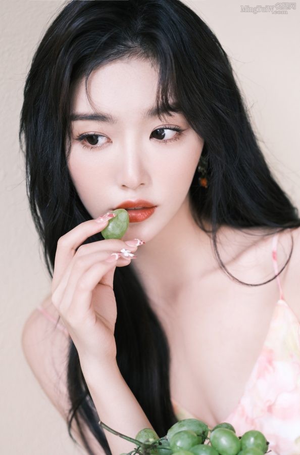 Kong Xueer wears a low-cut skirt with suspenders to show off her smooth legs. The green grapes and red lips are so sexy.(3/7)