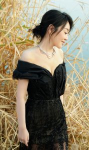 闫妮身着黑色薄纱裙站在芦苇丛里展示成熟事业线