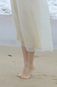 陈瑶白脚丫穿人字拖凉鞋走在海滩上