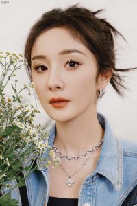 杨幂美腿穿细高跟长靴在一片草丛中展现青春活力气息