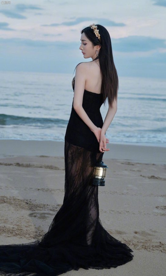 杨幂穿扇贝护胸礼服薄纱裙摆透美腿站在海滩上(4/13)