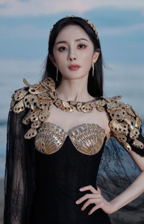 杨幂穿扇贝护胸礼服薄纱裙摆透美腿站在海滩上(11/13)