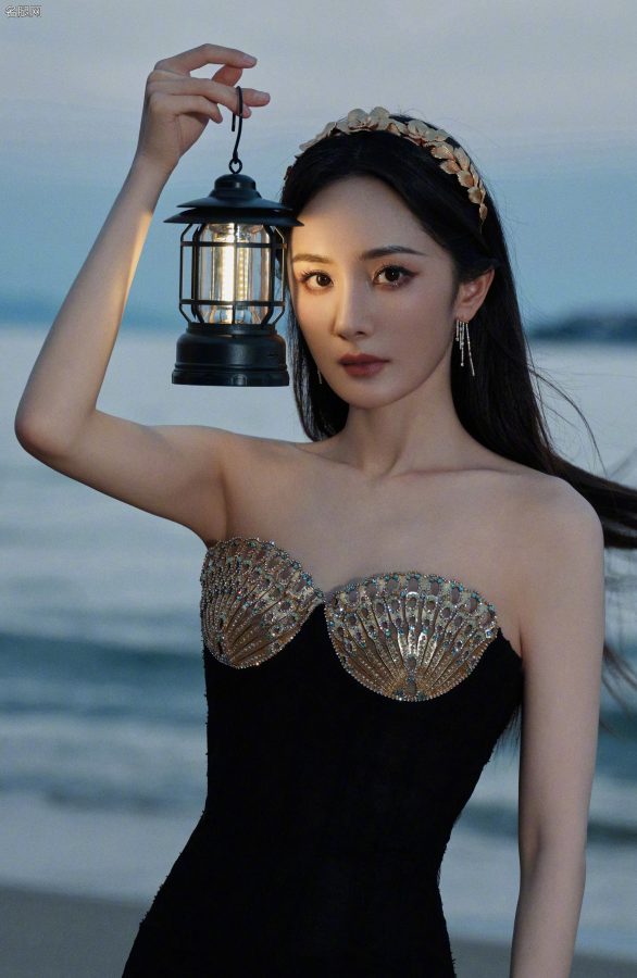 Yang Mi wore a scalloped breast-protecting gown and a tulle skirt with transparent legs while standing on the beach.(9/13)